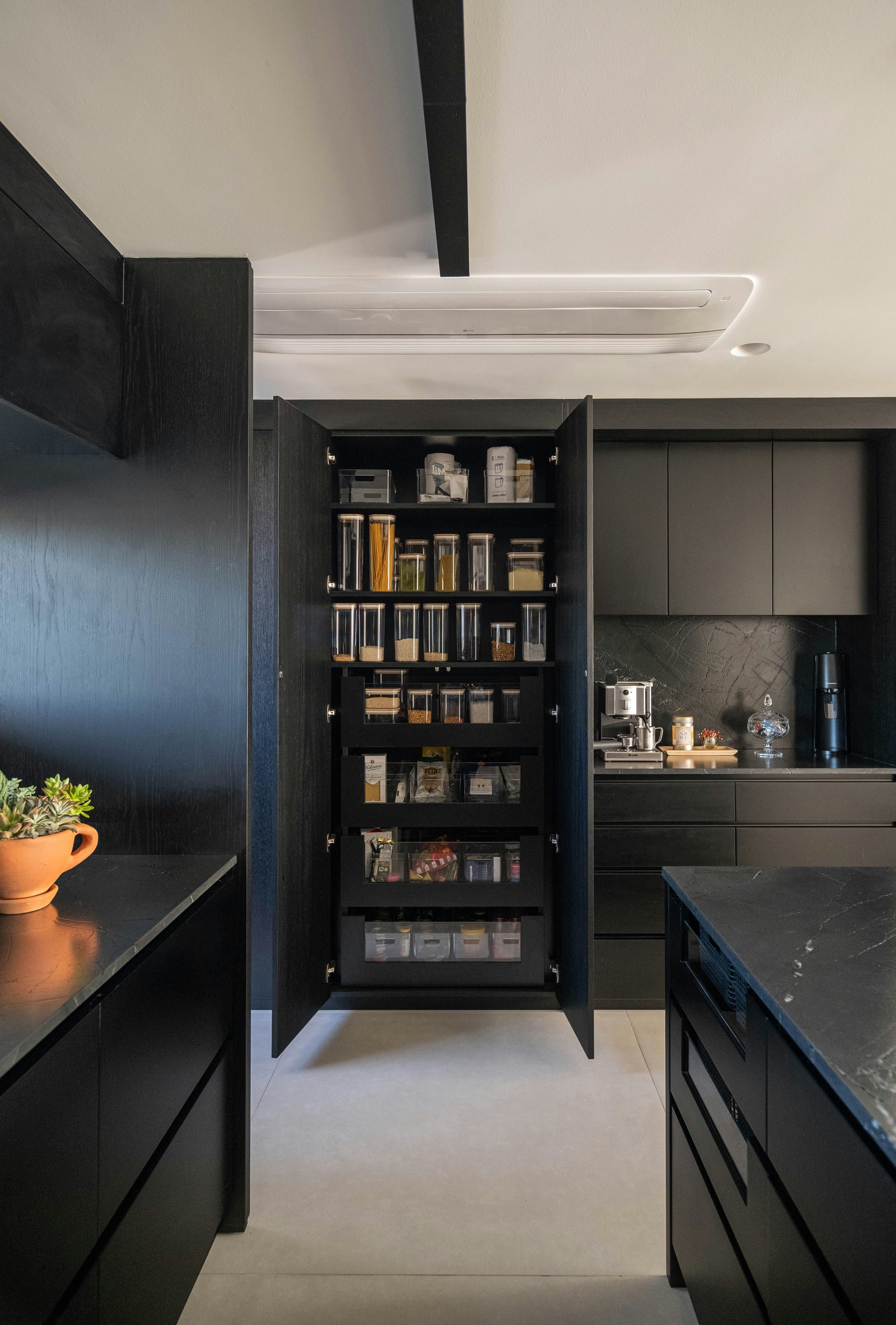 Black tall unit opened to show jars and organised shelves