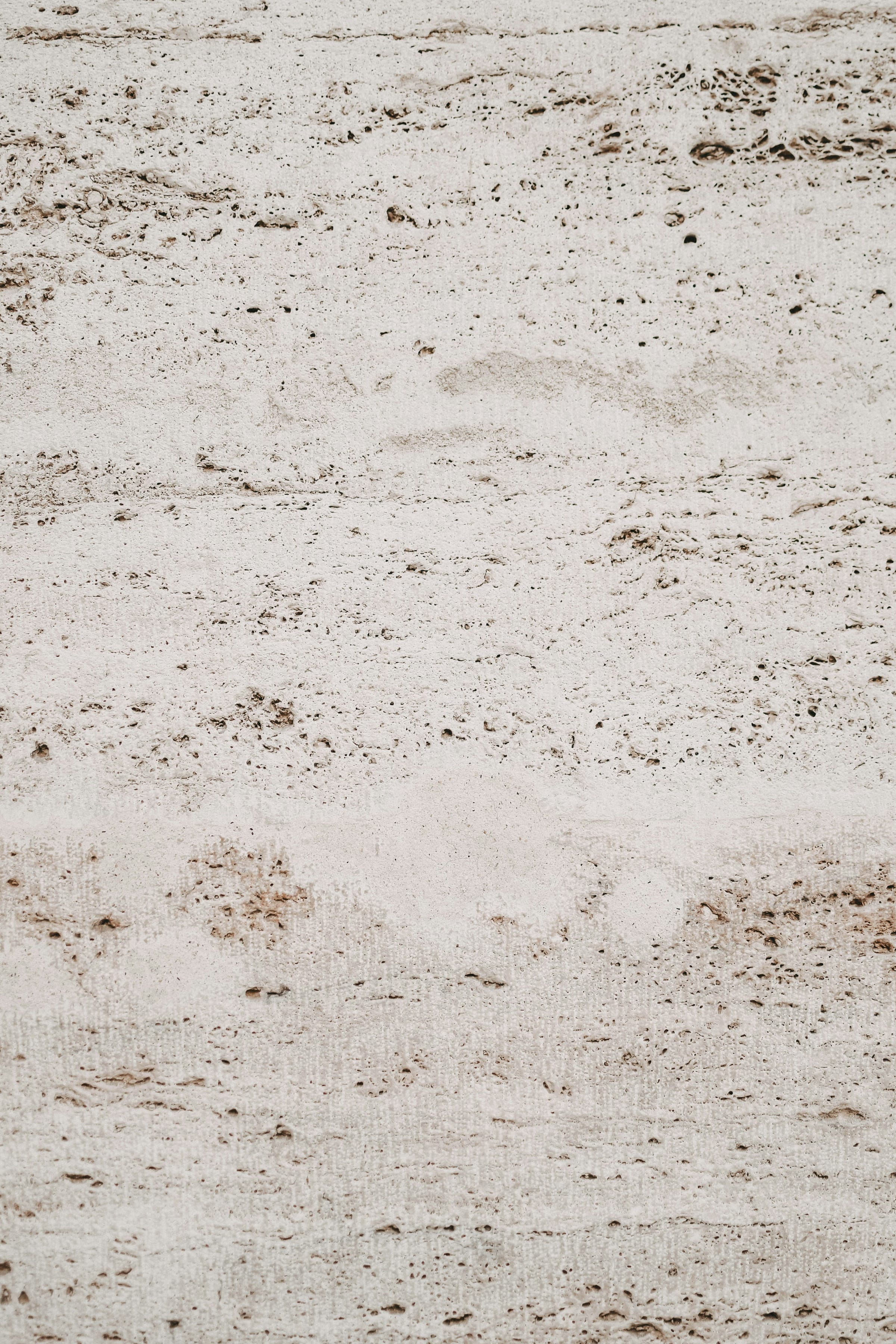 Pale surface in a travertine look, with soft brown pitting and a warm beige tone